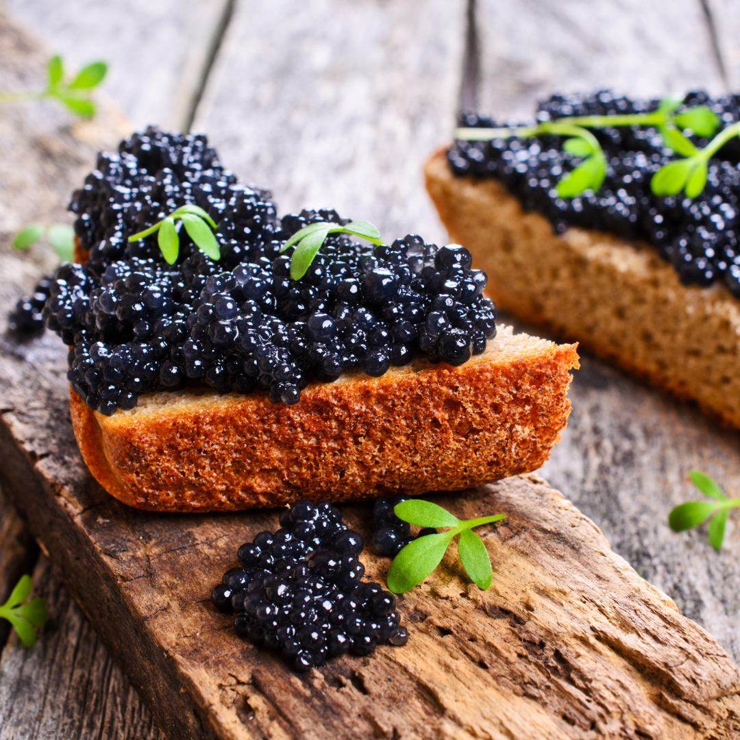 du caviar déposé sur une tranche de pain grillé et tout cela sur une belle table en bois massif
