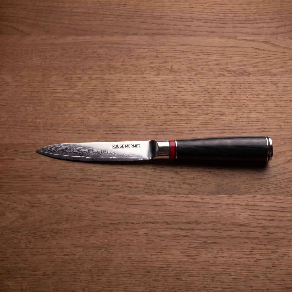 Couteau d’office Rouge Mermet en acier Damas VG10, lame de 10 cm, sur plan de travail en bois