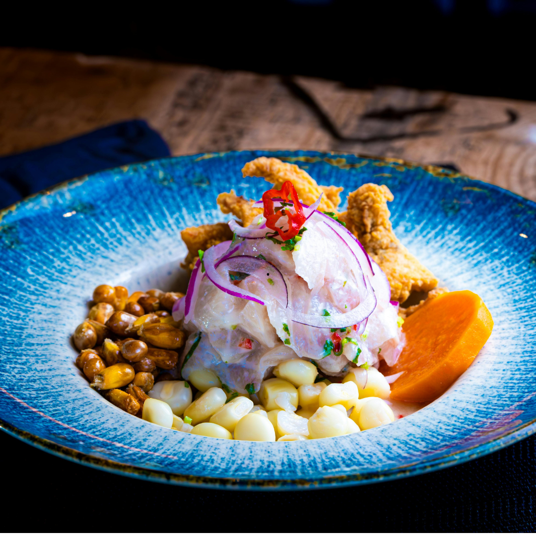 une assiette en porcelaine bleu dans laquelle il y a un plat gastronomique principalement composé de légumes