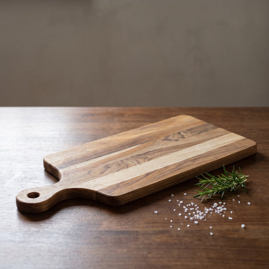 Planche à découper en chêne massif Rouge Mermet avec poignée, sur une table en bois